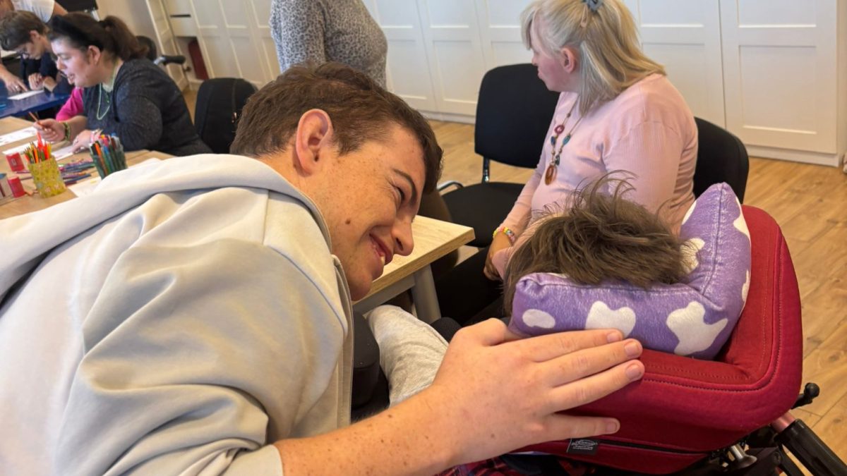 Dečko u sivoj majici s osmijehom na licu